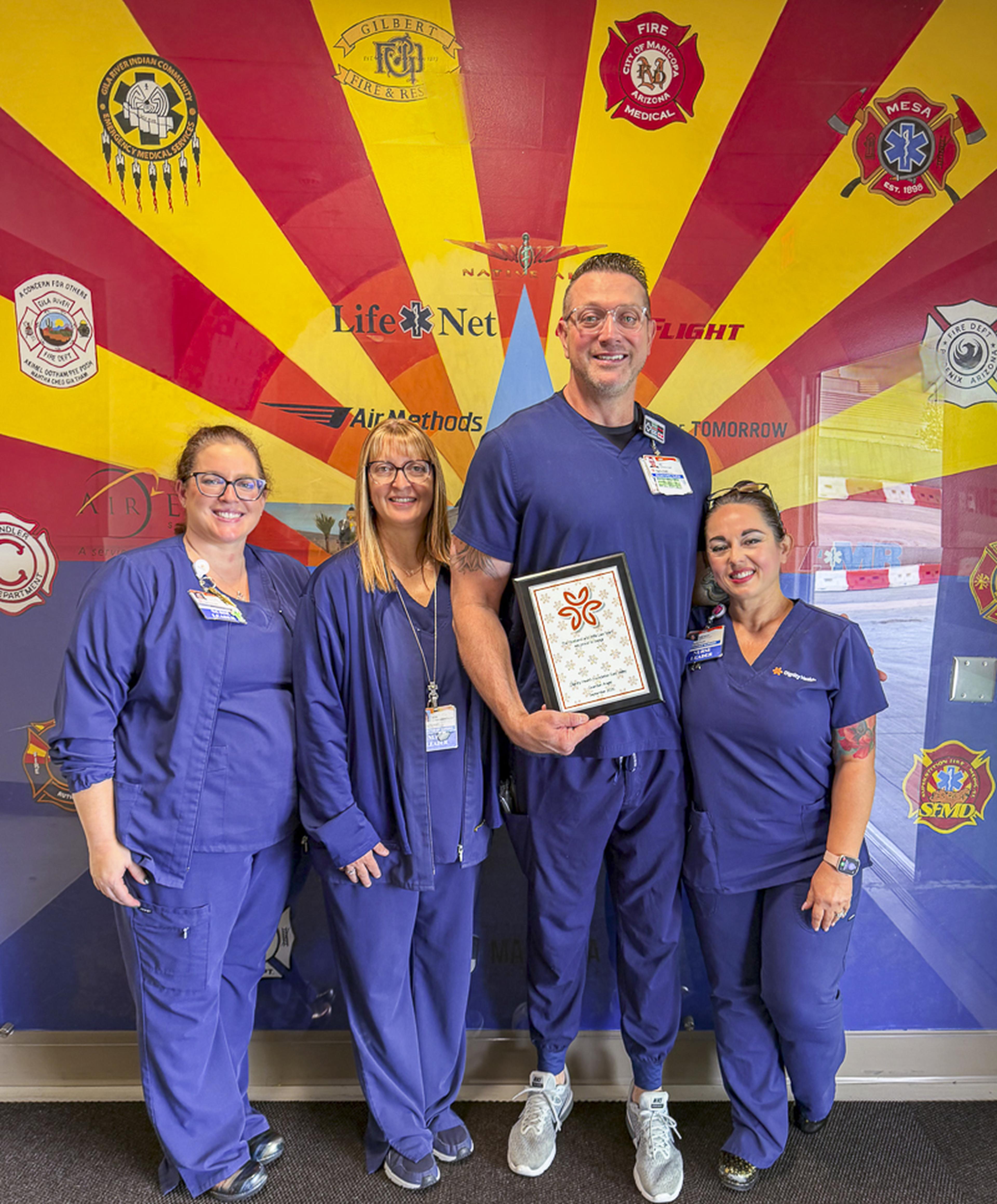A team of dedicated healthcare professionals celebrates alongside a Guardian Angel Award recipient, recognizing exceptional compassion, commitment, and patient care.