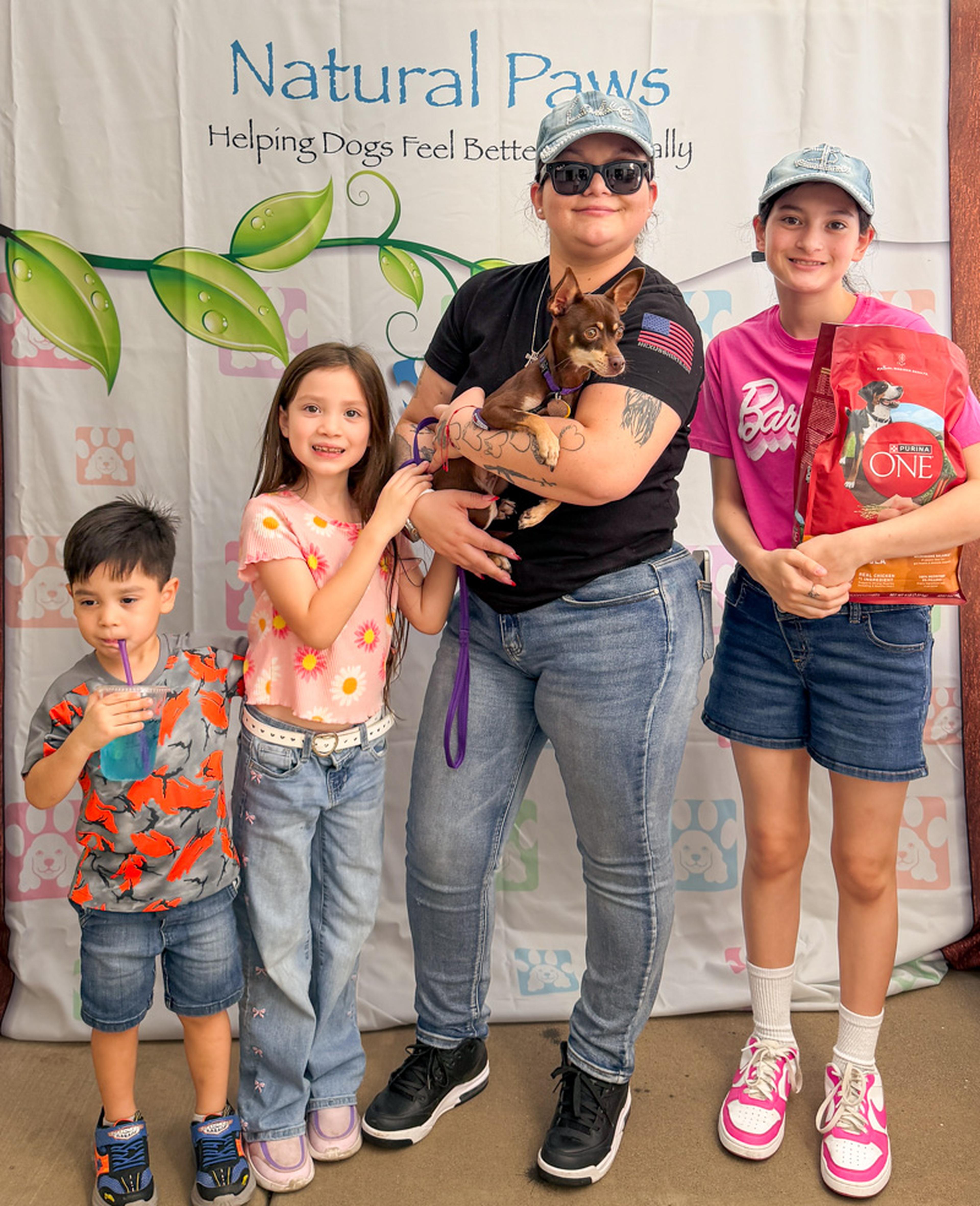 Smiles all around as a family poses with their small dog at the Husband & Wife Law Team’s HALO Adoption Event, highlighting the joy of pet adoption and responsible pet ownership.