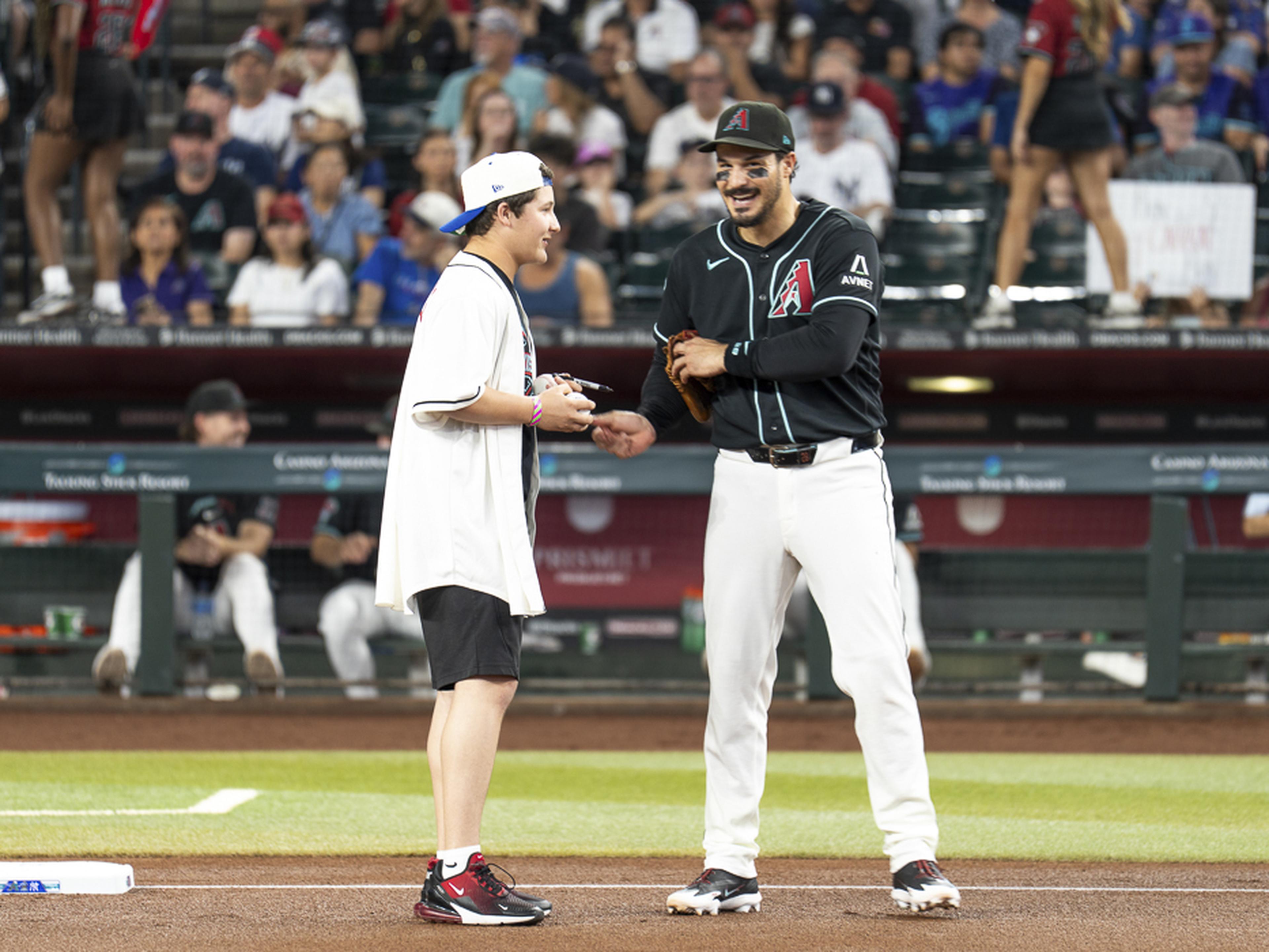 An Arizona Diamondbacks player shares a smile and conversation with a young Kids Take the Field participant on the field, creating a memorable game-day experience that will last a lifetime.