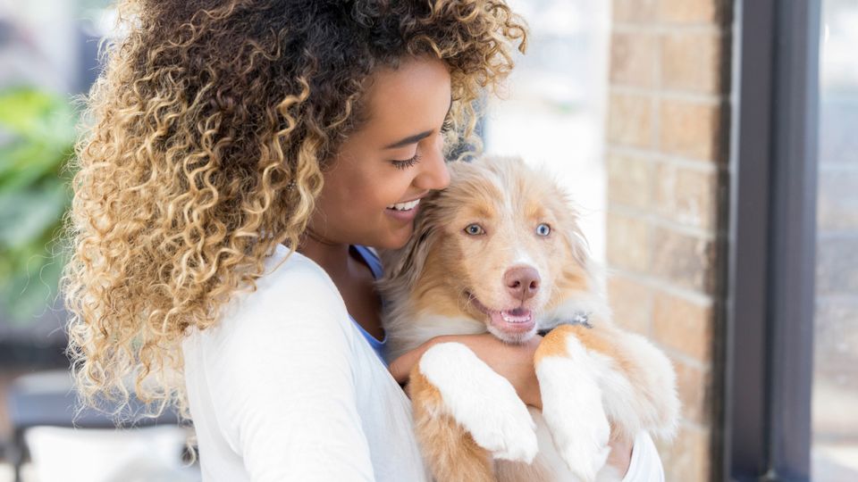 woman holding smiling puppy