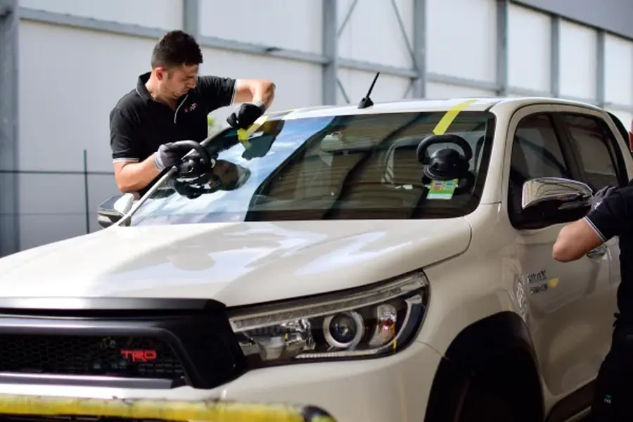 MWT technician fitting a windscreen to a ute