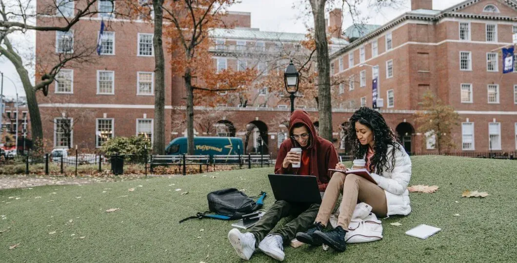 students-sitting-at-park-working