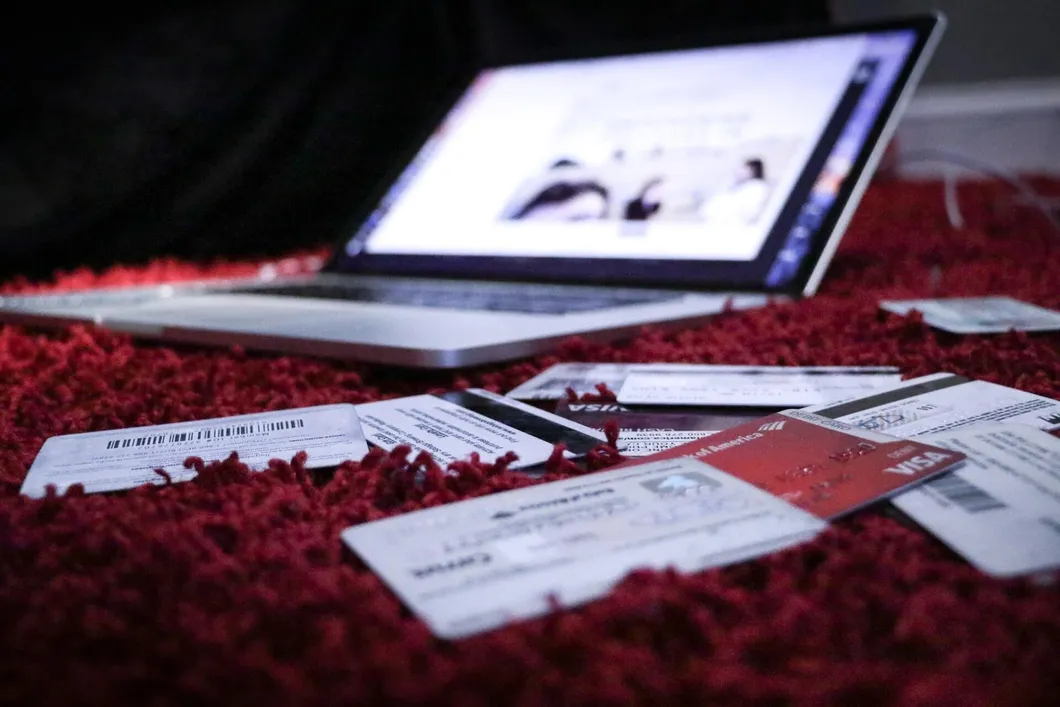 Laptop and credit cards on a red rug