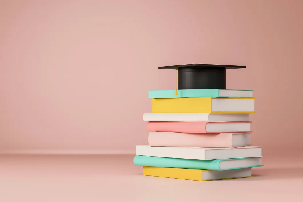 stack-of-books-and-black-graduation-cap-on-pink-background