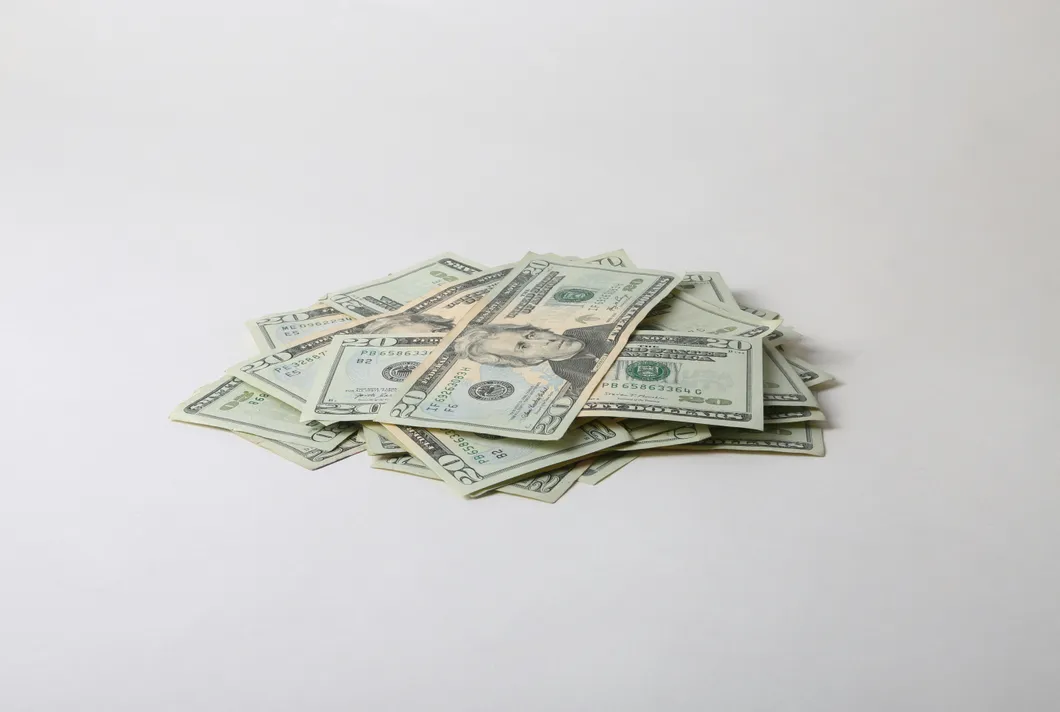 a-pile-of-money-sitting-on-top-of-a-white-table
