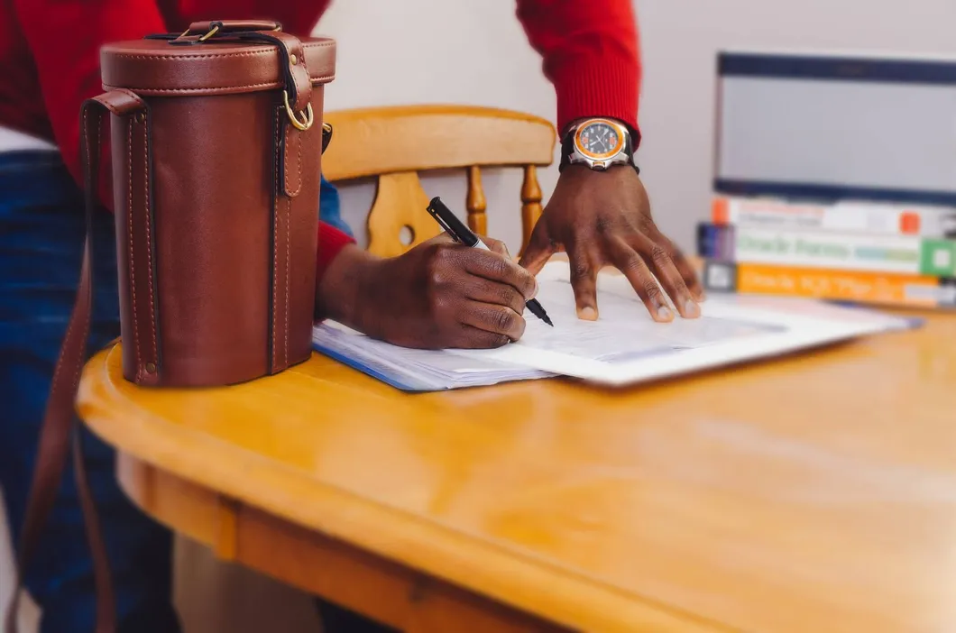 person-signing-documents-at-table