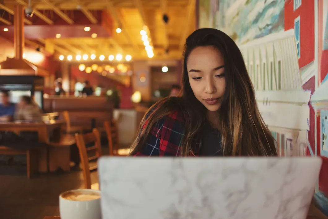 Woman working on laptop at cafe