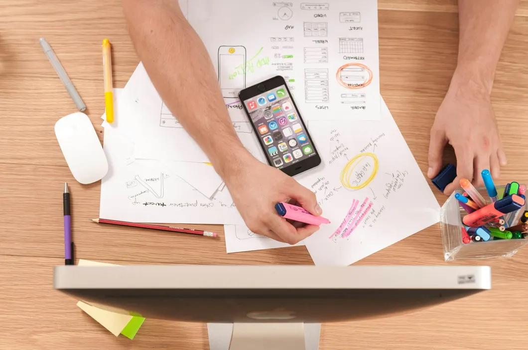 Student-working-at-laptop-with-phone-and-papers
