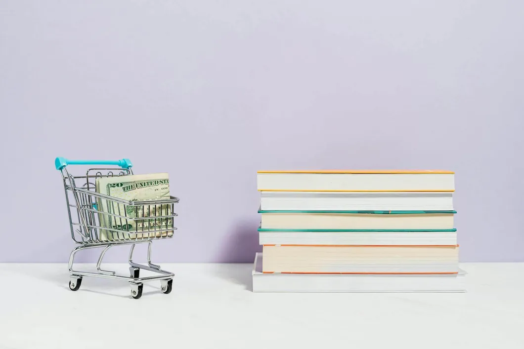 tiny-shopping-cart-with-money-in-it-next-to-books