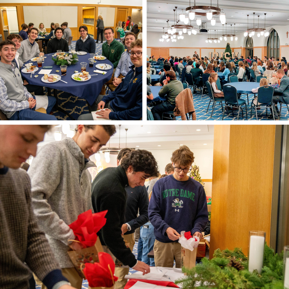 People at a festive gathering, with groups dining and exchanging gifts in a decorated room with chandeliers and holiday decor.