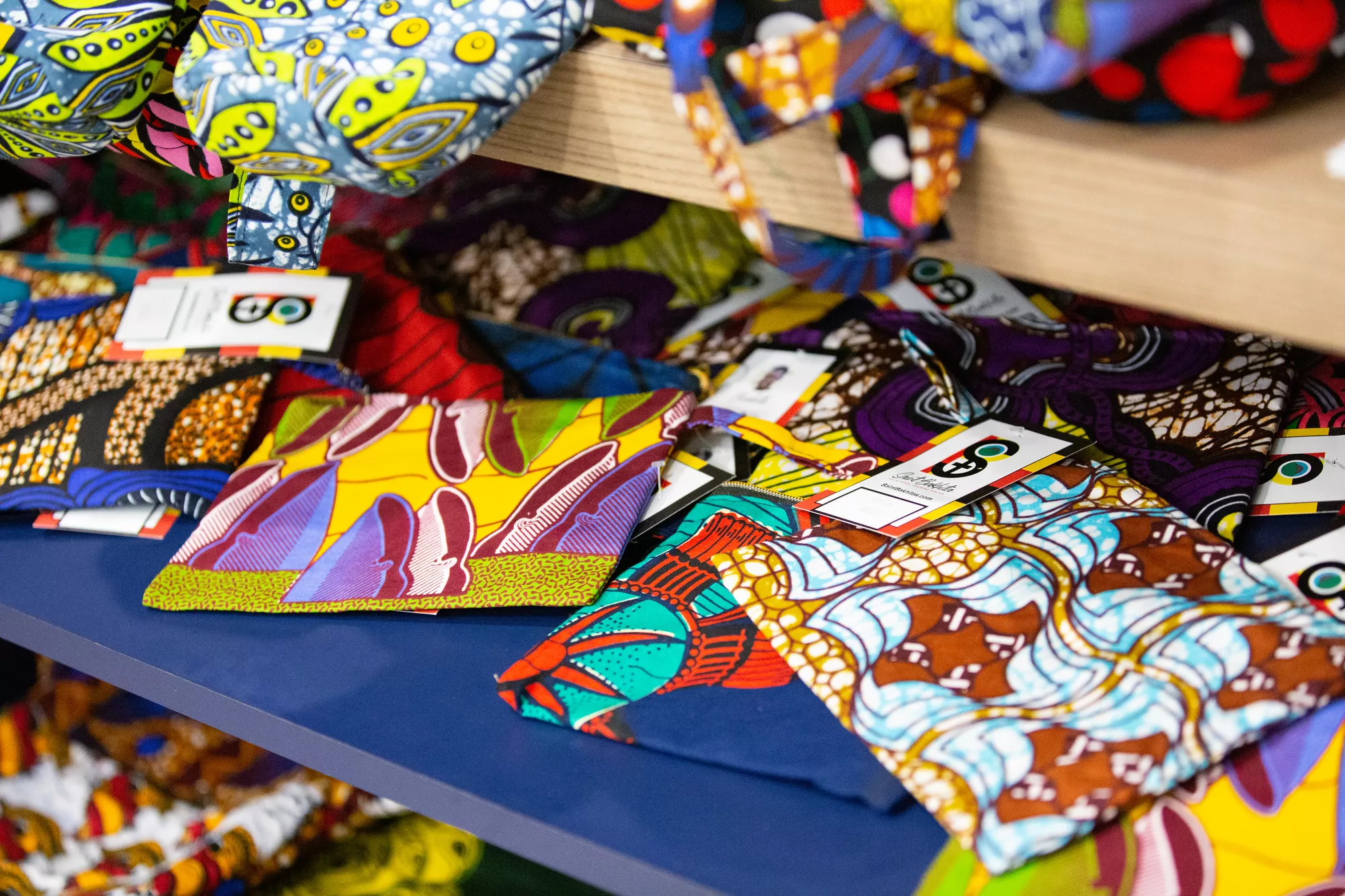 A selection of brightly colored fabrics strewn across a table.