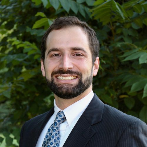 Mark Hoipkemier Headshot in front of green vegetation wall