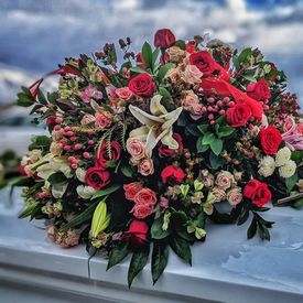 A large bouquet of flowers lying on a casket.