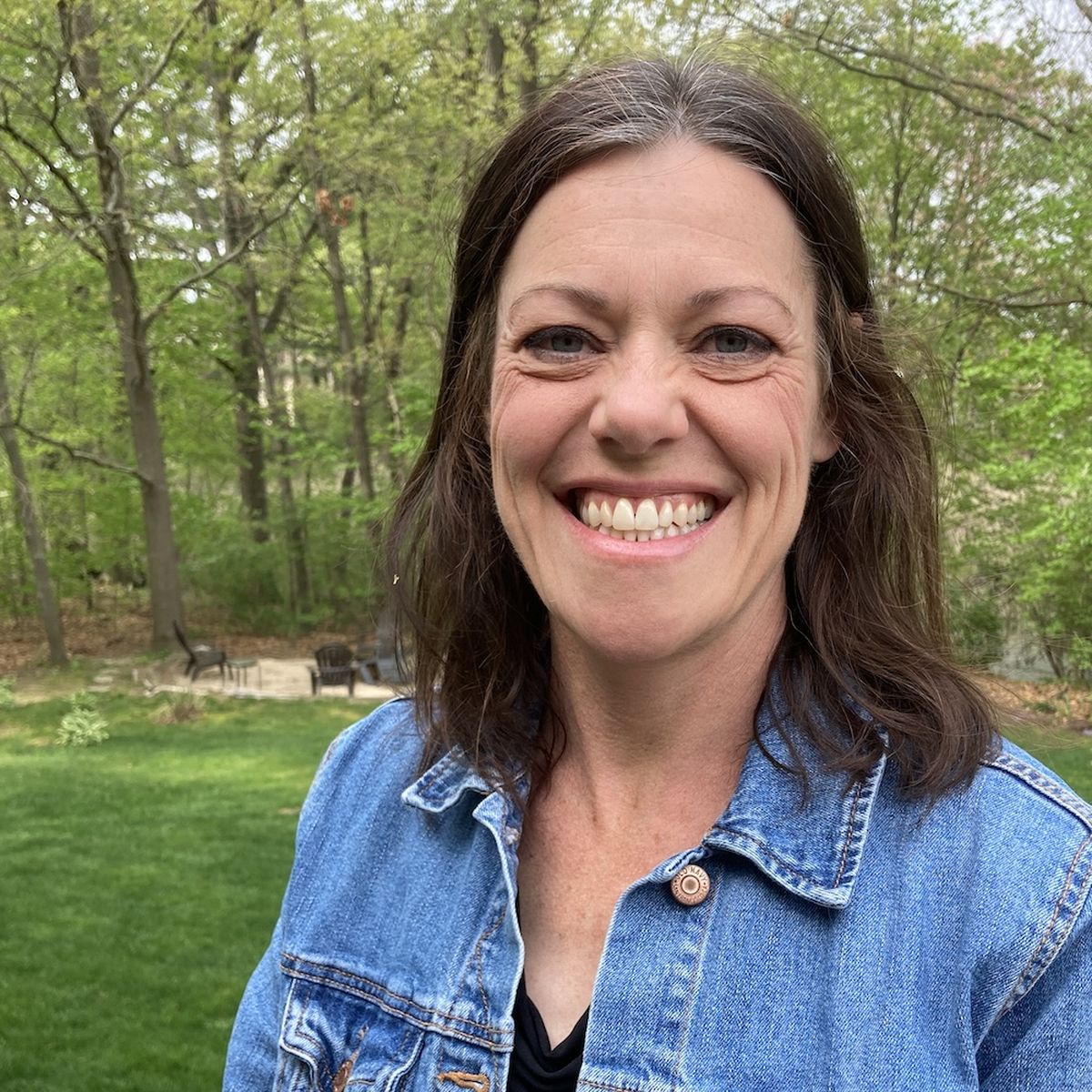 A photo of a smiling, middle-aged white woman with dark, shoulder-length hair.