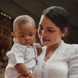 A young mother holds a baby.