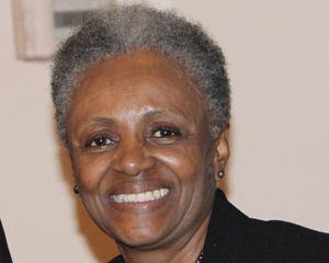 A smiling woman with short, curly hair.