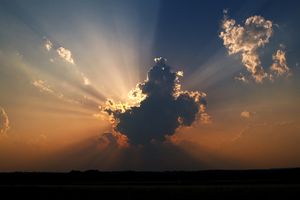 Image of Sun rising behind clouds representing the Holy Spirit
