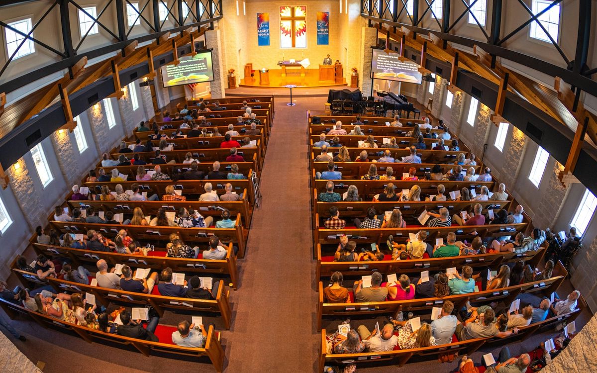 An overhead view of full pews in a church.