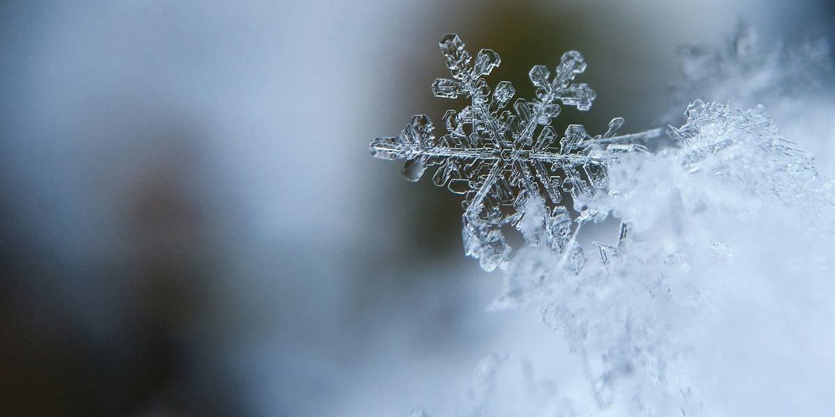 A close up view of a snowflake with six arms.
