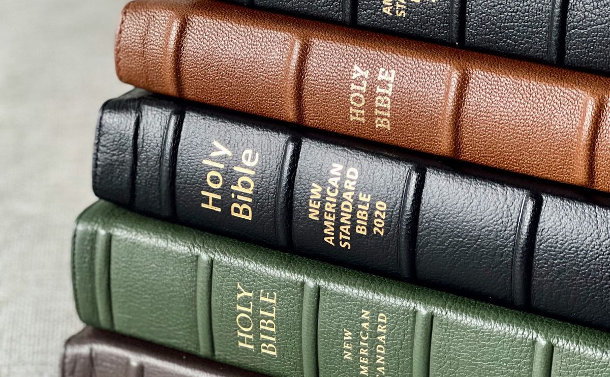 A stack of new, leather-bound Bibles of different colors.