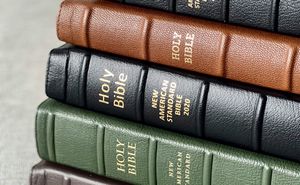 A stack of new, leather-bound Bibles of different colors.