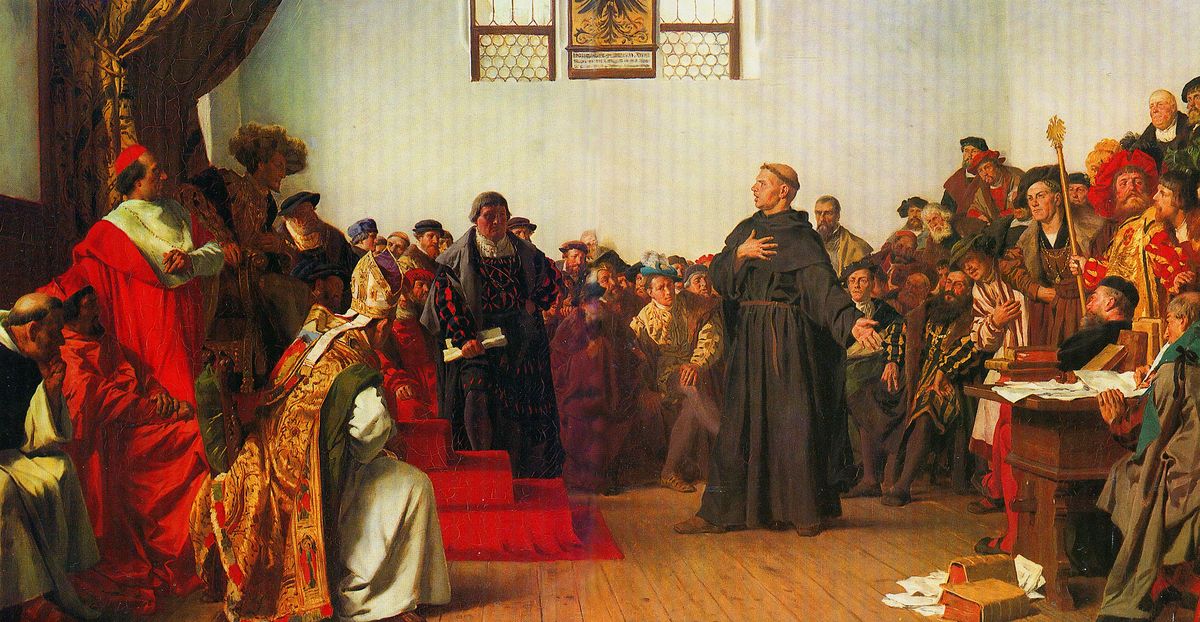 Depicts Luther, tonsured and with monk's garb, standing before a group of people, speaking.