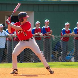 A young man at bat prepares to swing at a pitch.
