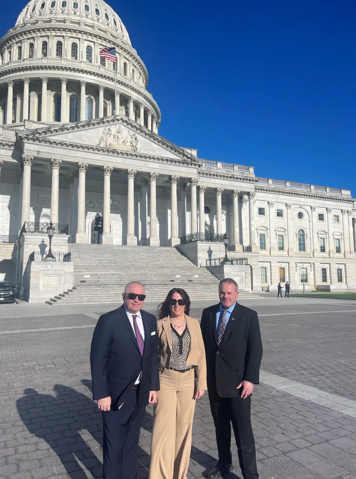 ASNT CEO Neal Couture, Director of Public Relations and Government Affairs Garra Liming, and ASNT board member Jason Riggs standing together in front of the US Capitol Building.