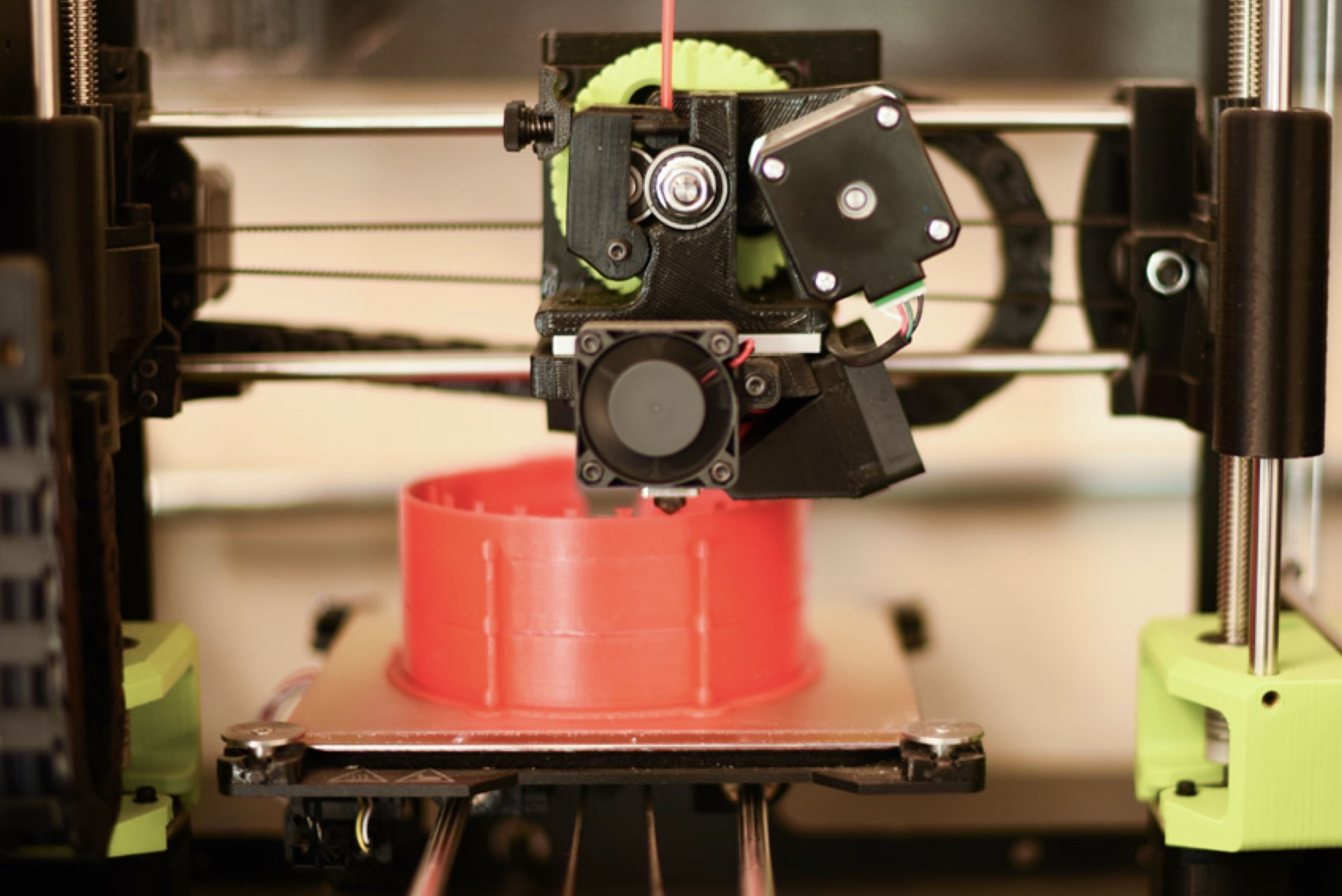 America Makes 3D printer producing a red additively manufactured component