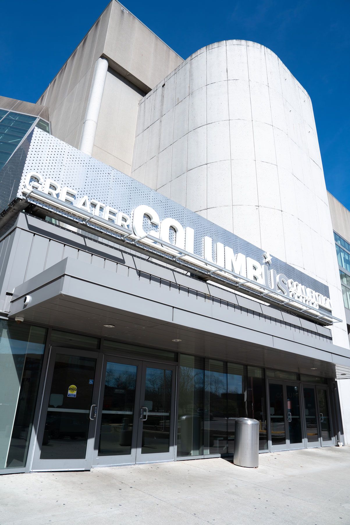 Photograph of the exterior of the Greater Columbus Convention Center, a large modern building with a curved white facade.