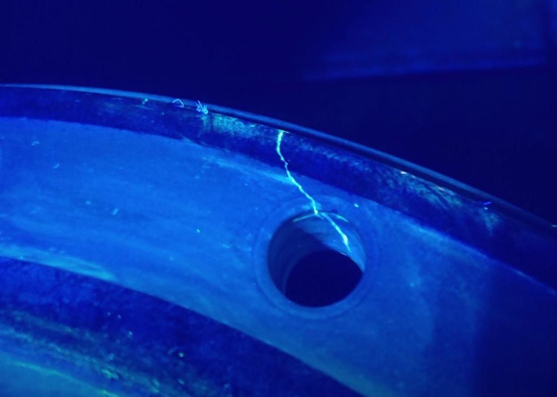 Fluorescent penetrant testing showing a fatigue crack originating from a fastener hole