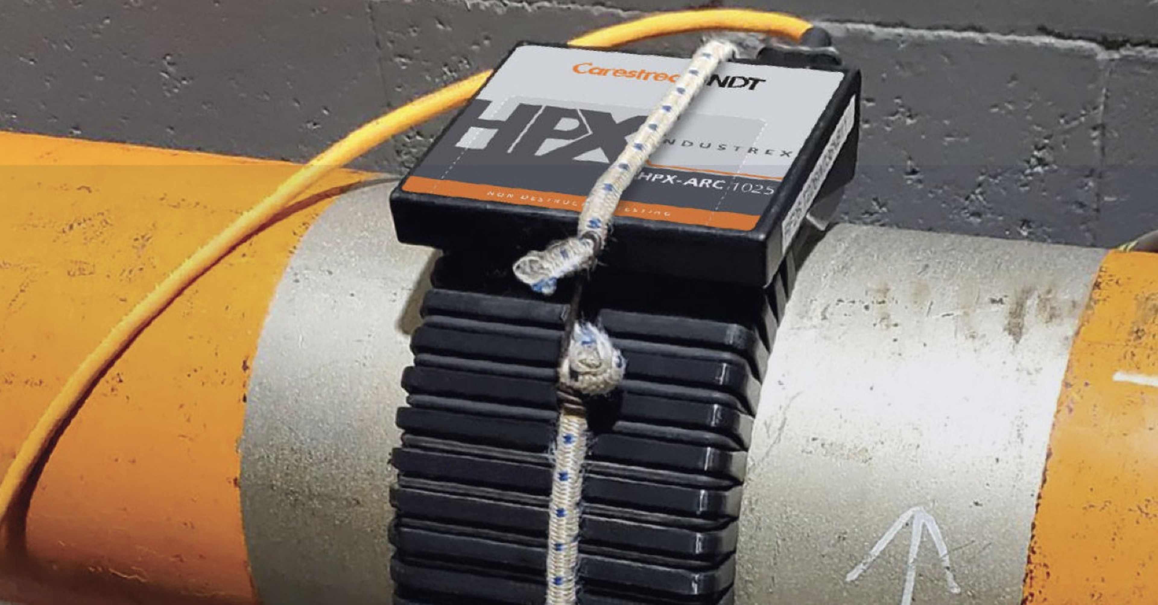 A Carestream NDT INDUSTREX HPX digital radiography detector mounted on an industrial pipe for radiographic inspection.