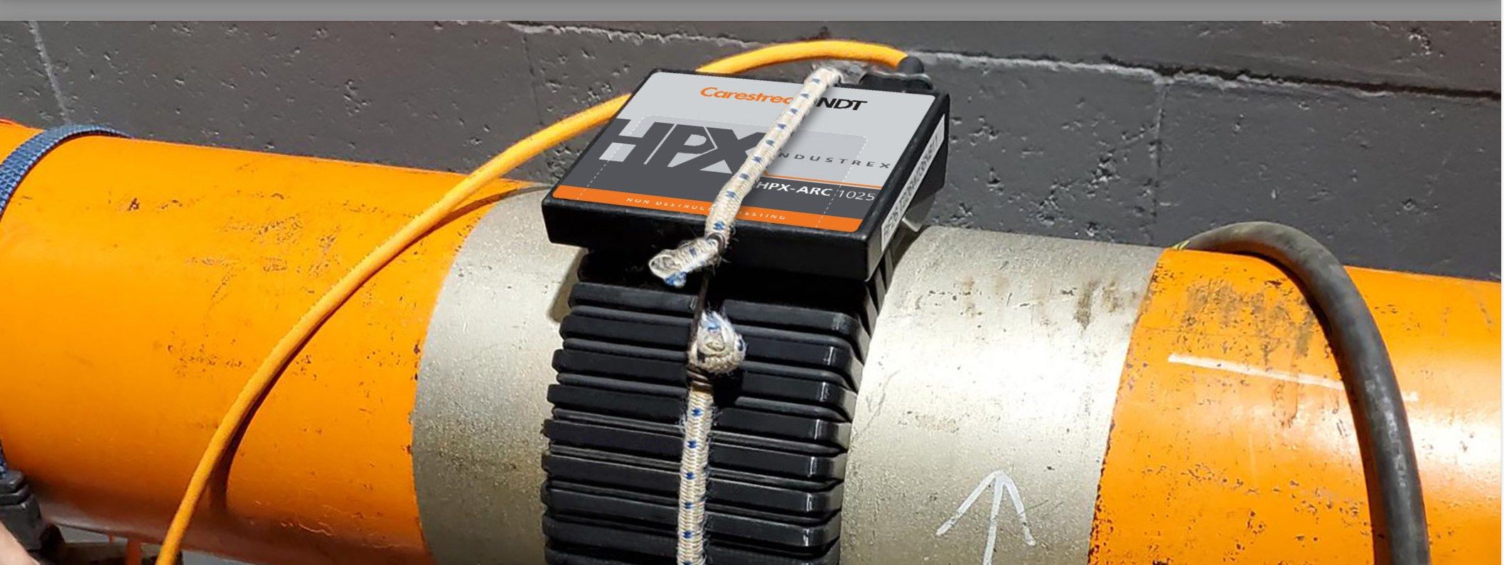 INDUSTREX HPX-ARC 1025 flexible detector strapped around an orange 8 in. diameter pipe