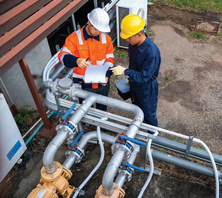 Two inspectors reviewing documentation at a pipeline