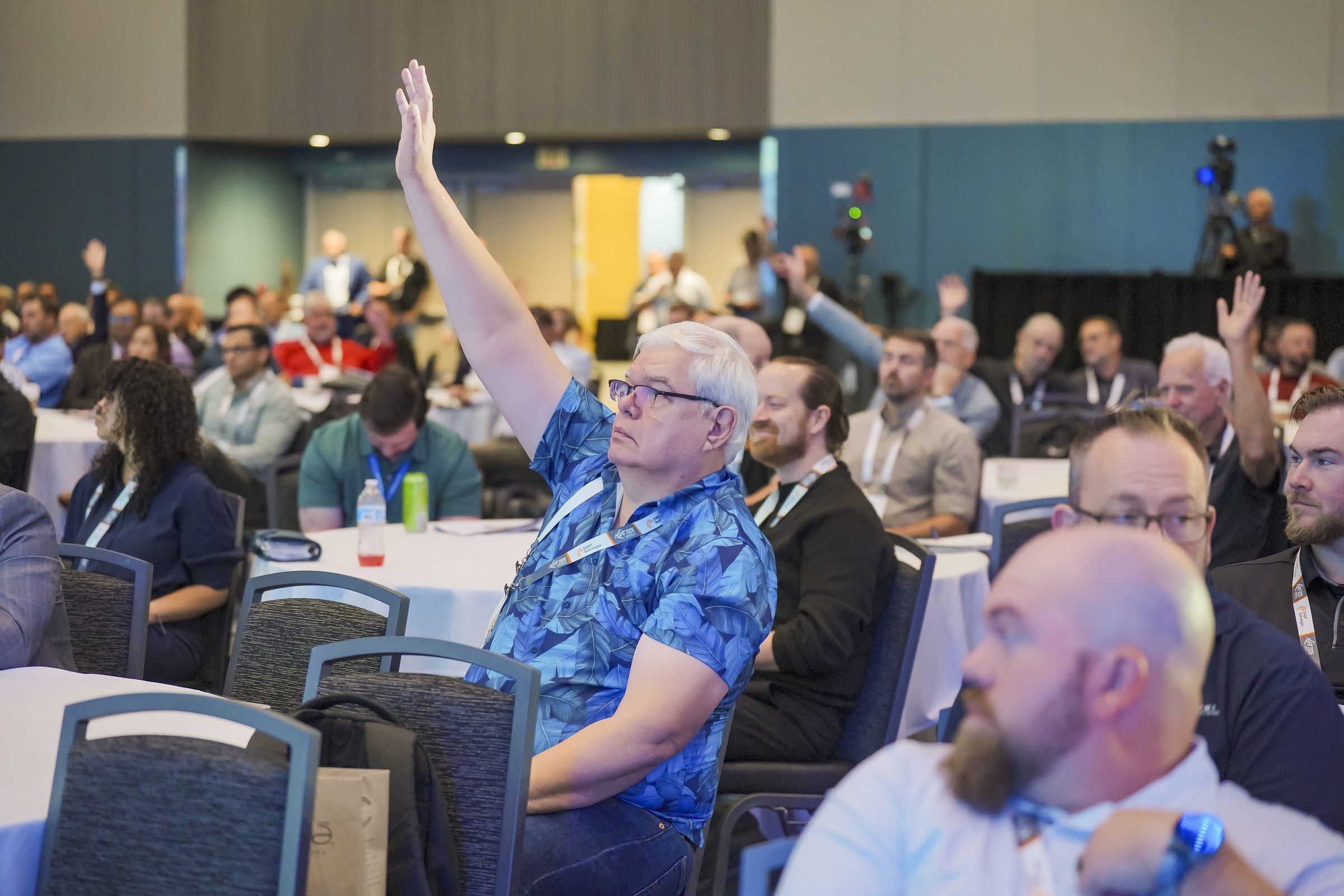 An attendee raises his hand to ask a question in a full room at ASNT 2026