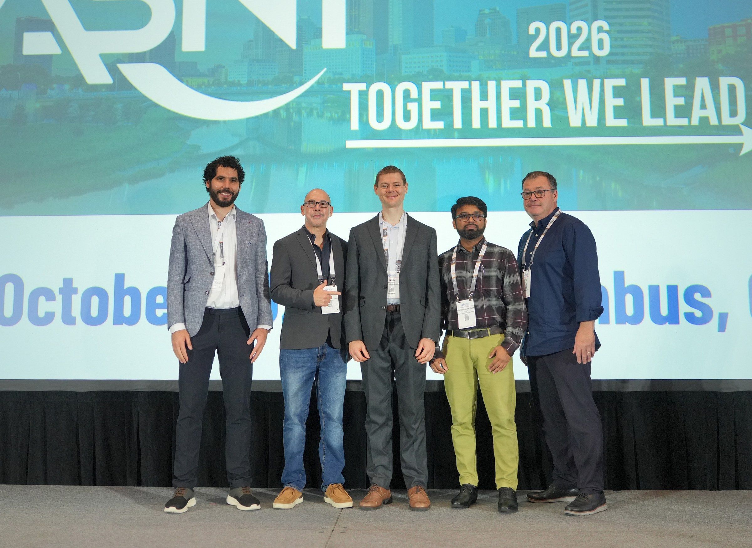 Five men standing onstage in front of an ASNT 2026 Together We Lead screen after the Battle of the AI Agents