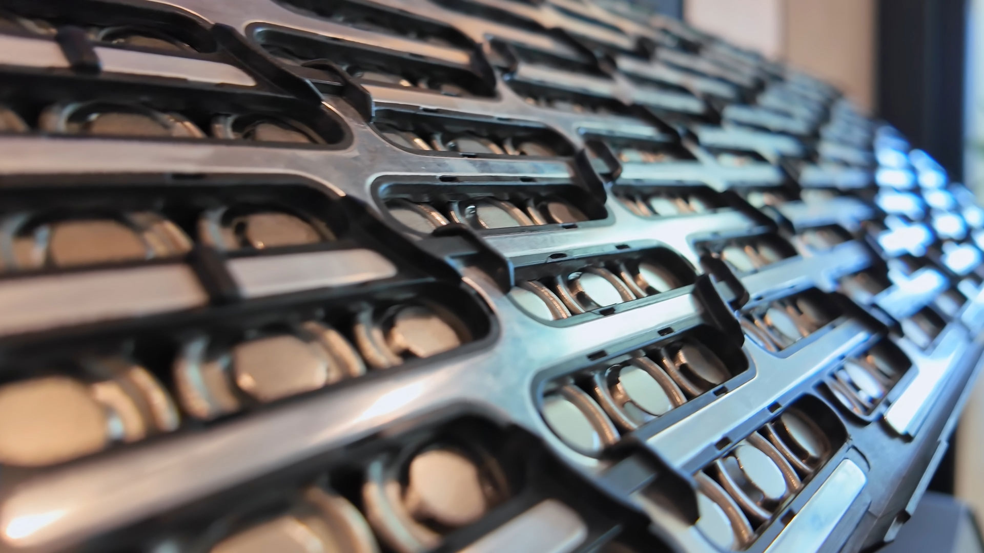 Rows of cylindrical lithium-ion battery cells arranged in a manufacturing module tray.