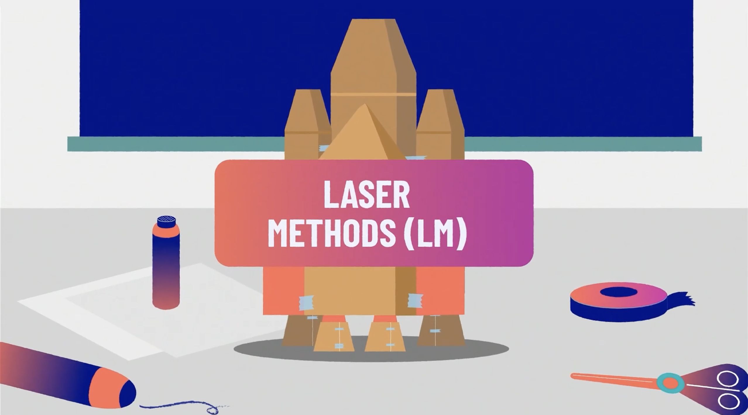 Cardboard rocket model with "Laser Methods (LM)" label, surrounded by crafting tools and materials on a table.