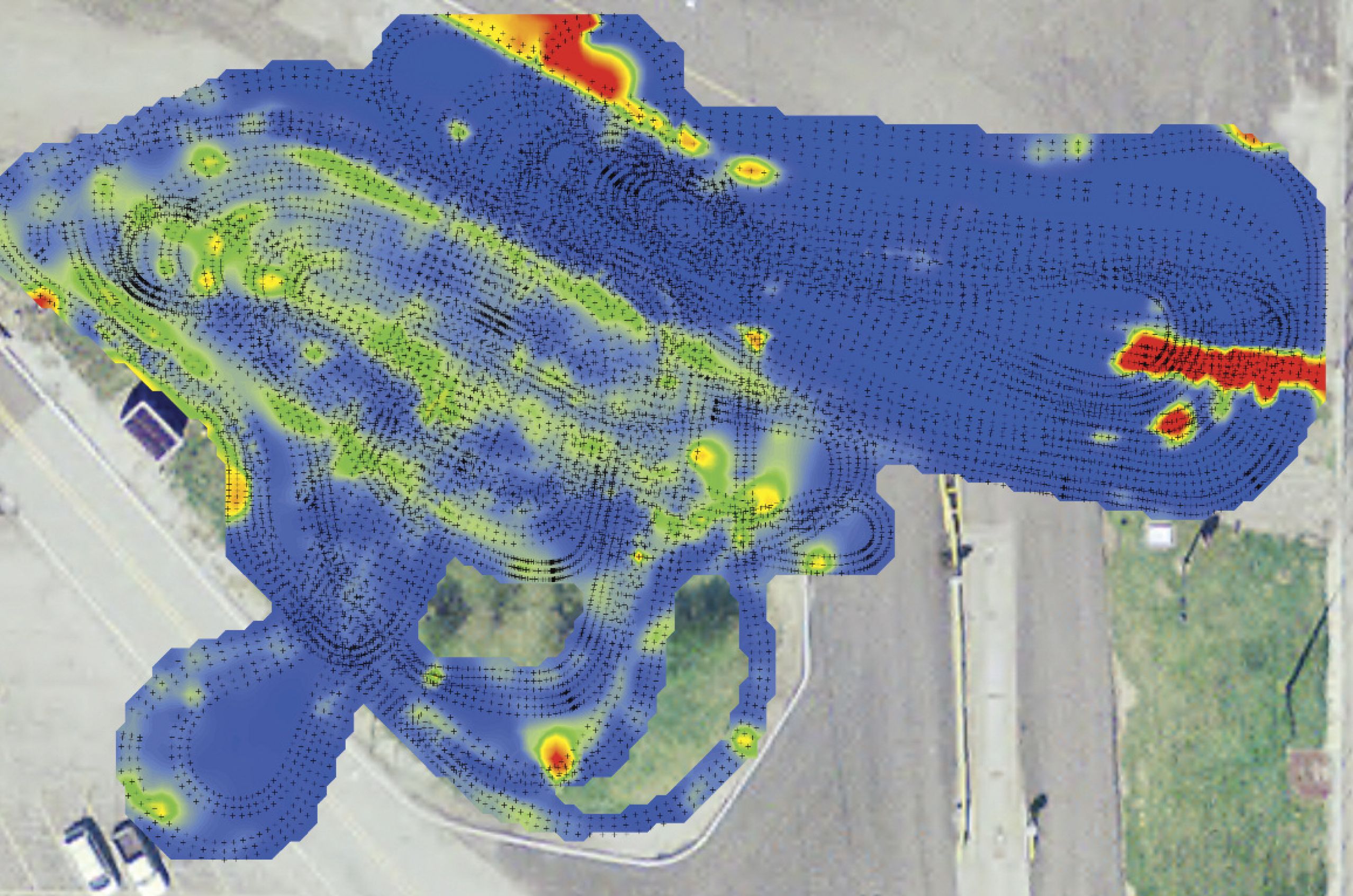 Ground penetrating radar (GPR) heatmap overlaid on an aerial photograph of a paved site, showing subsurface anomaly intensity across a parking lot or roadway area.