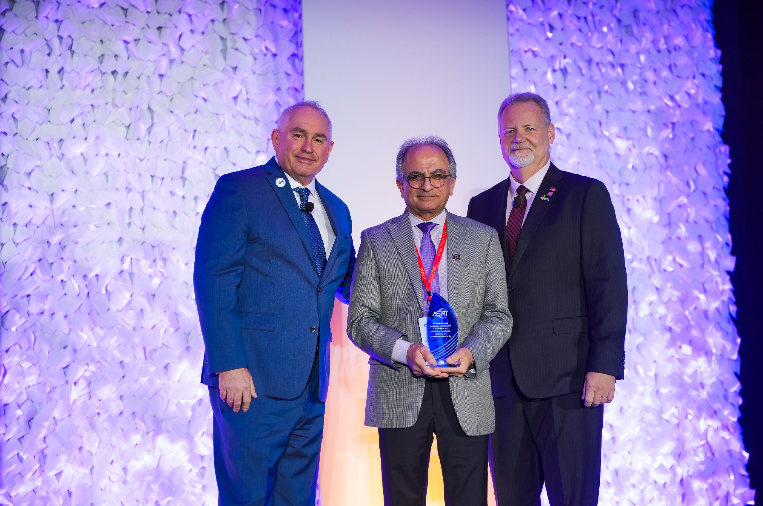 Crystalline trophies lined up in rows on a table.