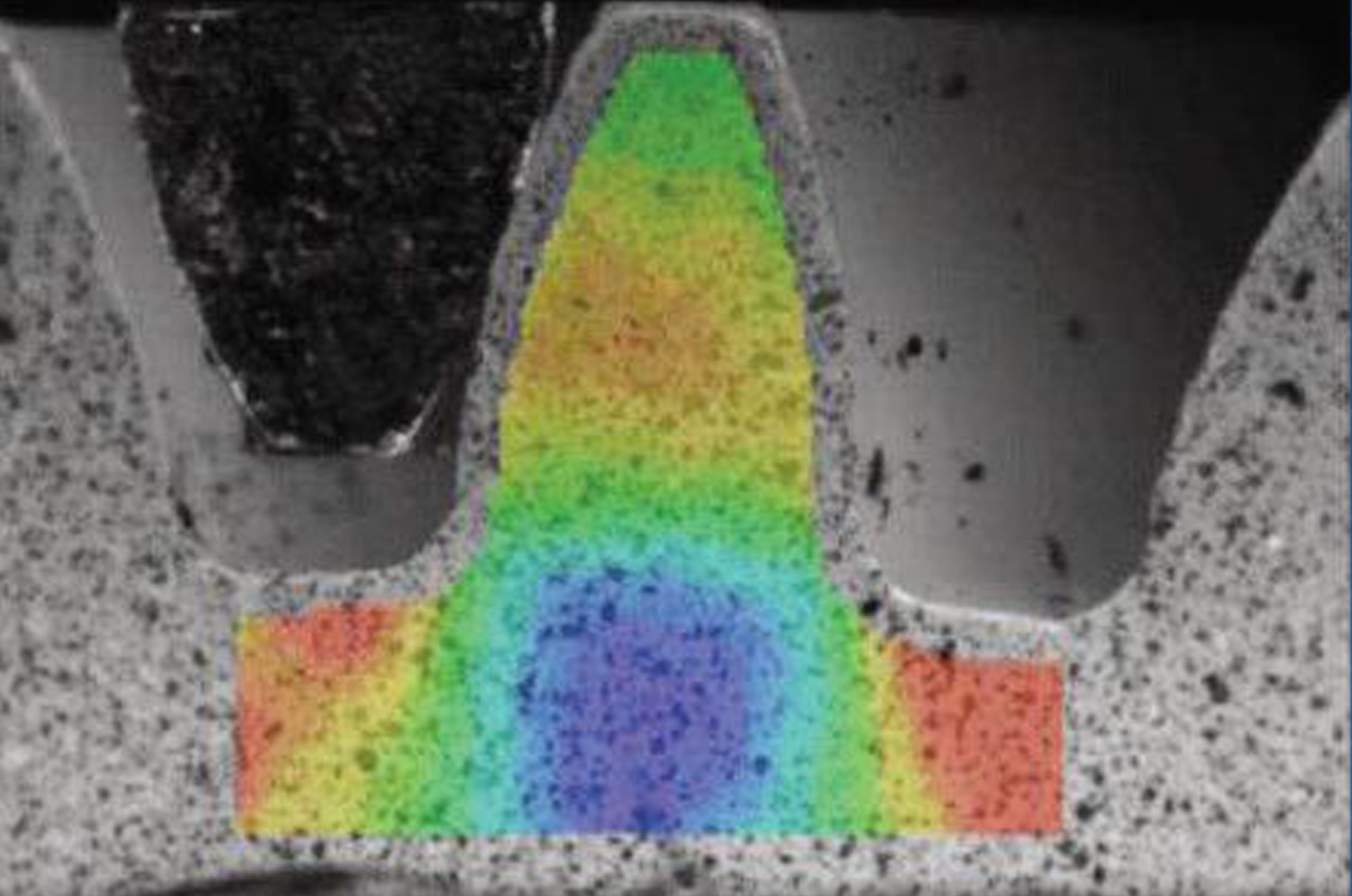 Cross-section of a part with a rainbow-colored stress pattern overlay.