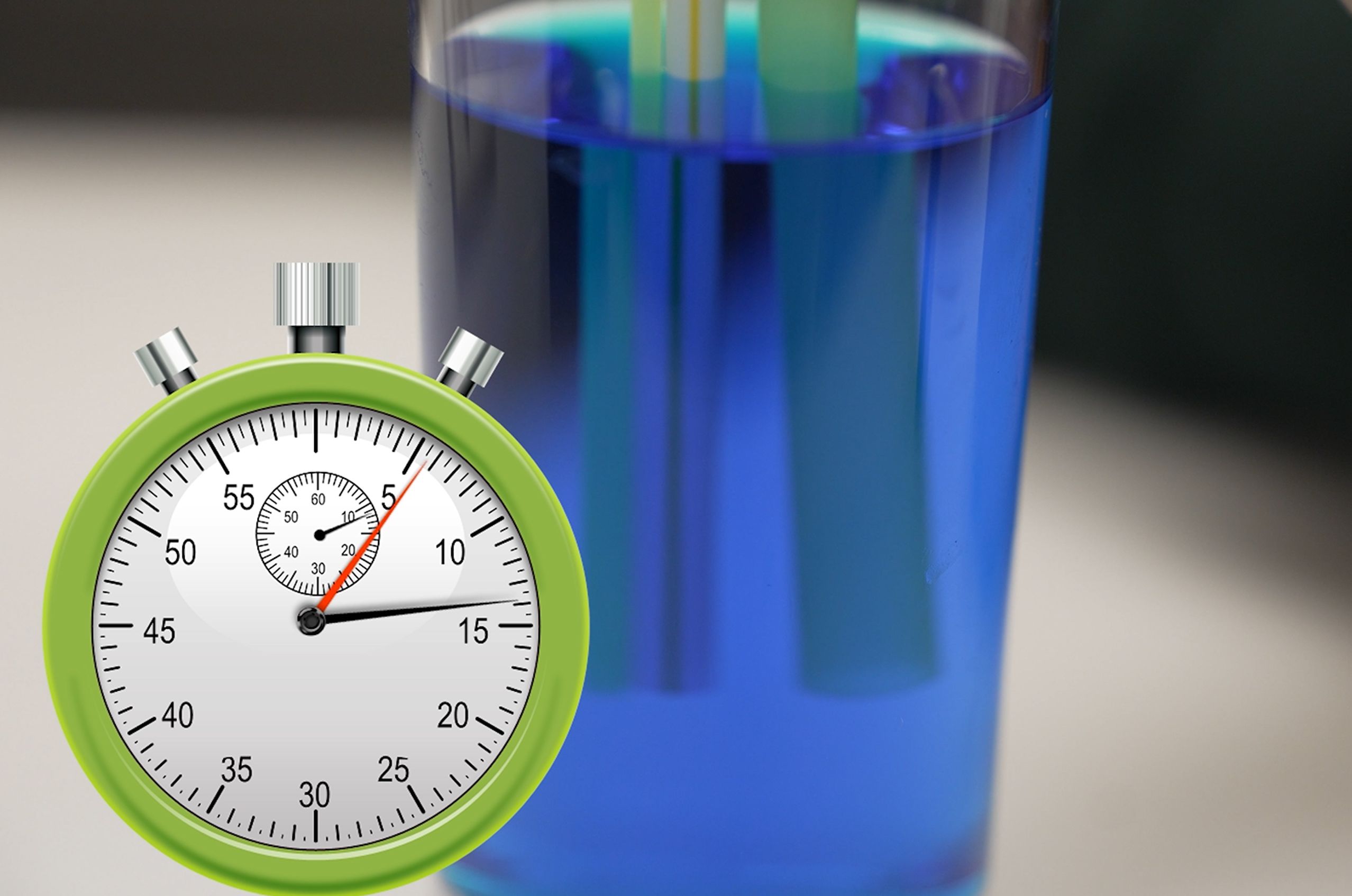 A green stopwatch overlays an image of a glass filled with blue liquid and submerged straws.