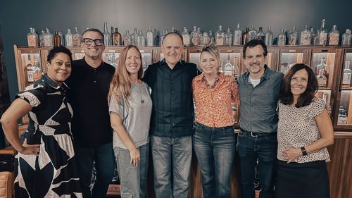 Group of At The Table guests posed together and smiling at the camera