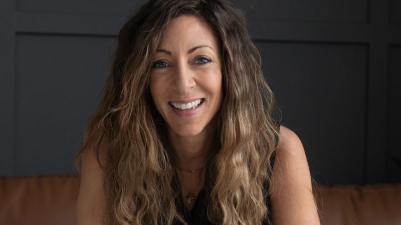 Ali Schwanke sitting on a couch smiling