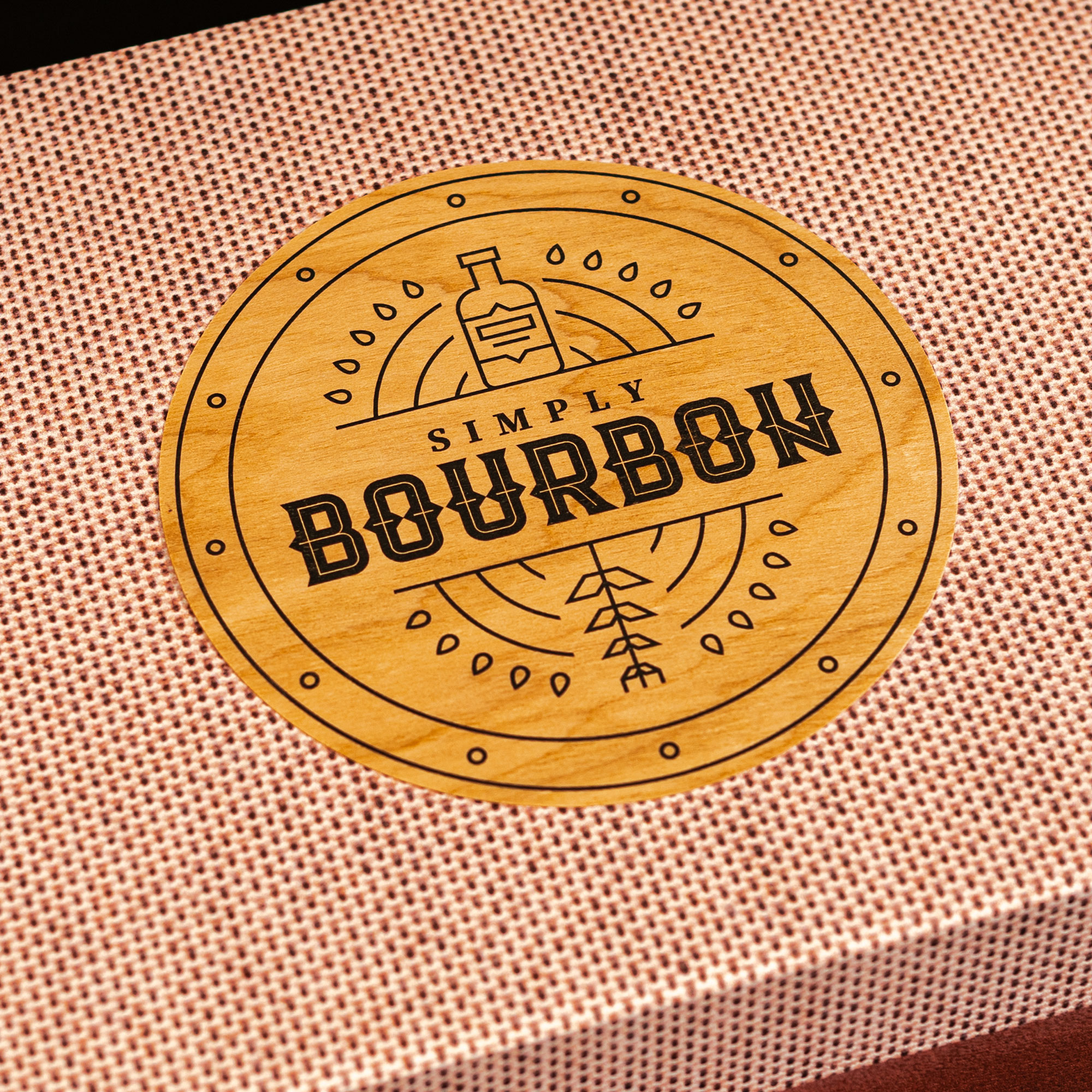 Close up of the promo box lid featuring a Simply Bourbon wood medallion