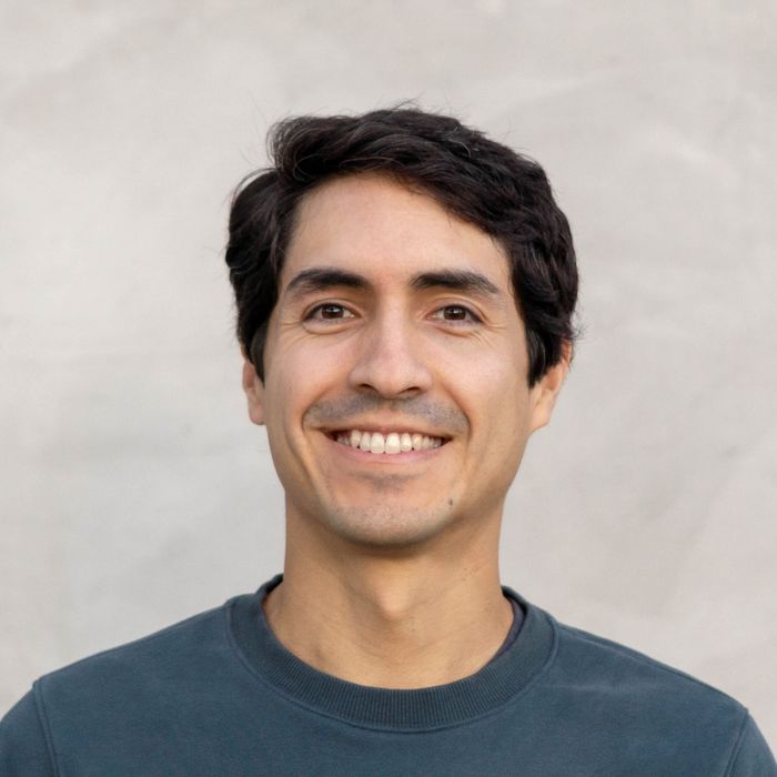 Edgar Tsuge smiling against a white wall