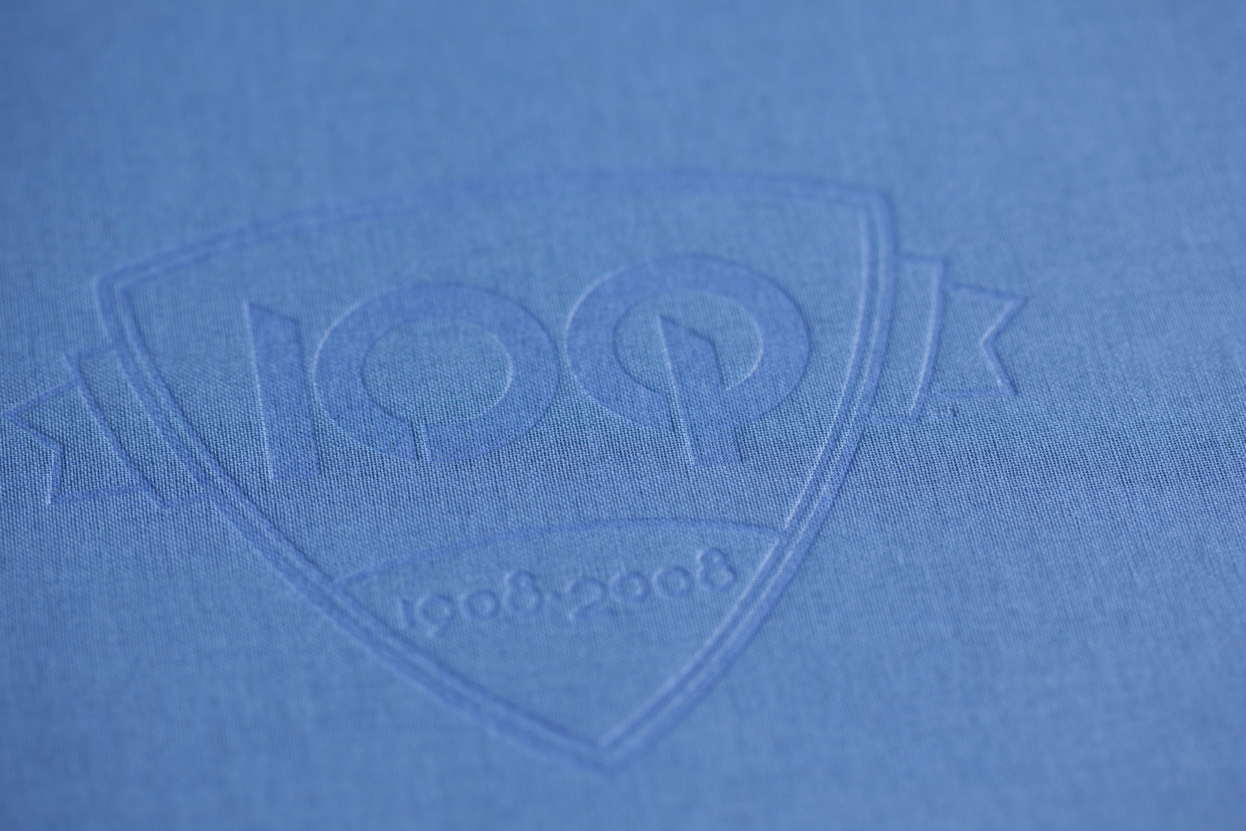 Closeup of the 100th anniversary O'Neil logo stamped into a fabric book cover