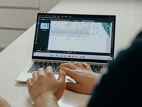 Person working on a laptop displaying architectural design software