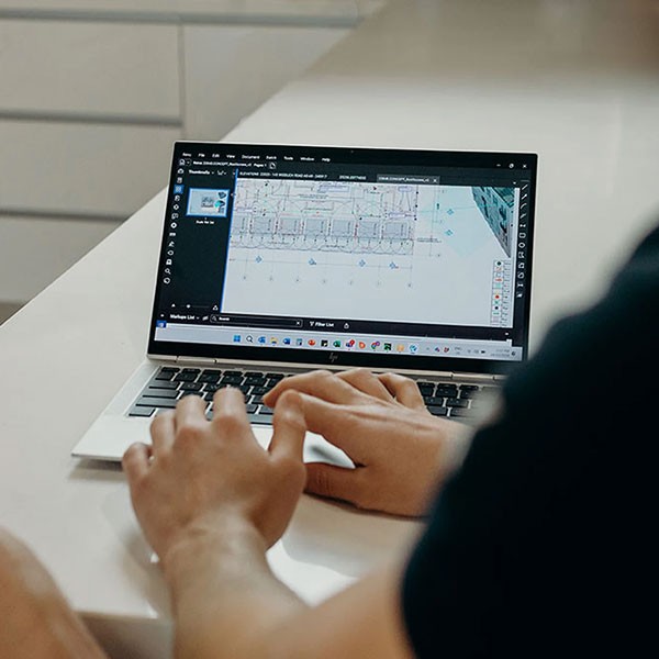 Person working on a laptop displaying architectural design software