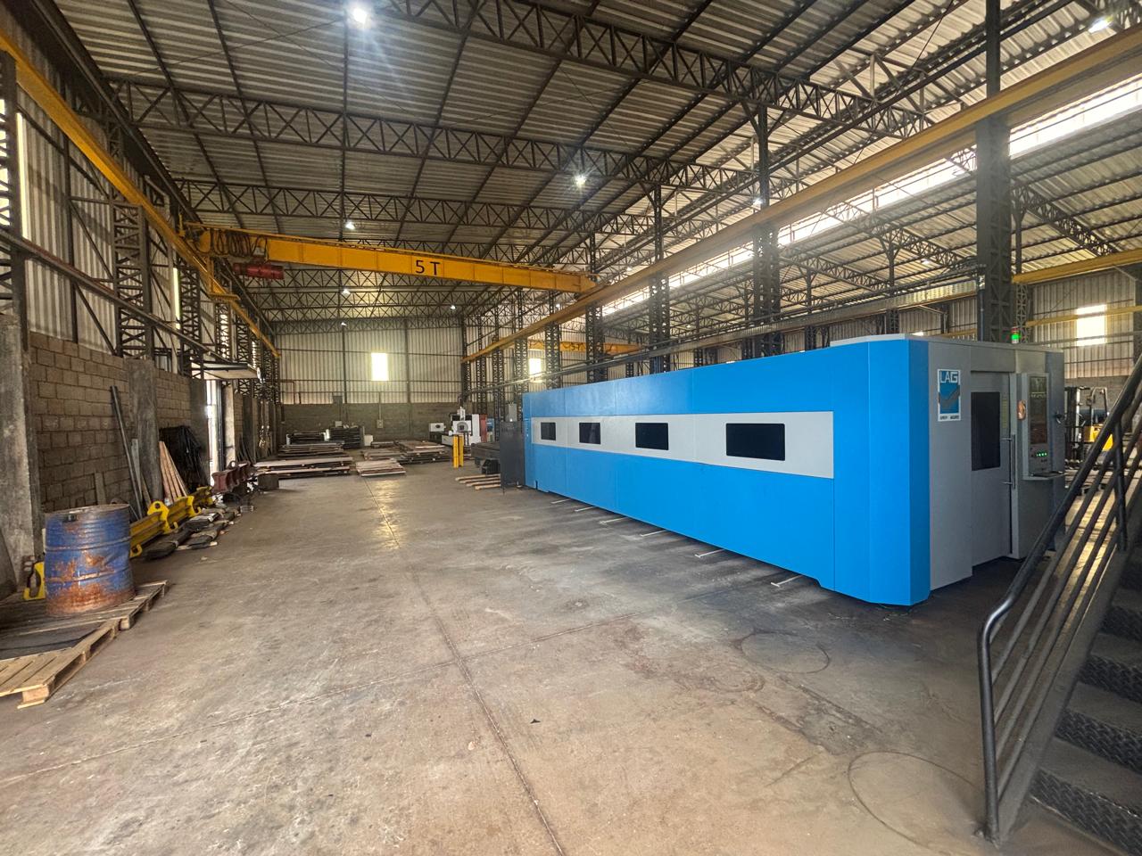 Máquina de fabricação metálica em ambiente fabril organizado.